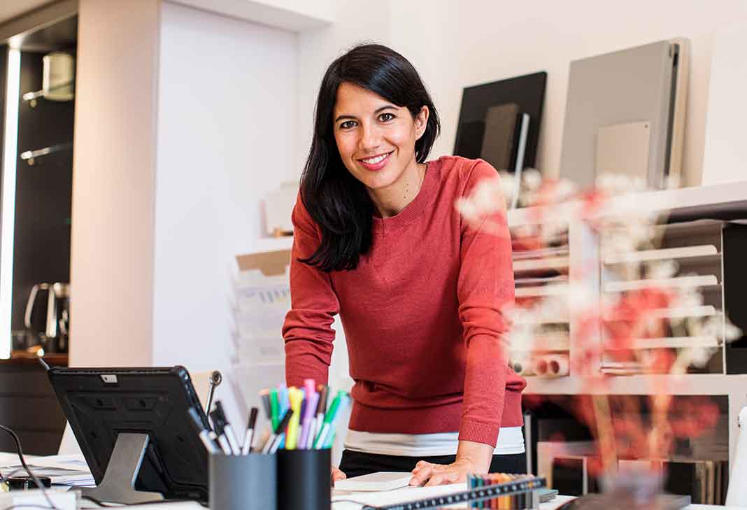 Woman leaning at desk smiling